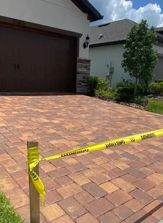 A brick driveway with a yellow caution tape around it