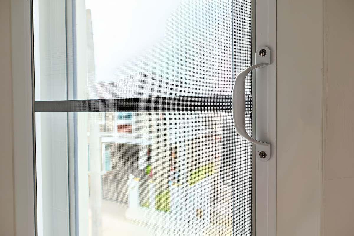 A Close Up of a Sliding Glass Door With a Handle — Manning Blinds & Awnings in Taree, NSW