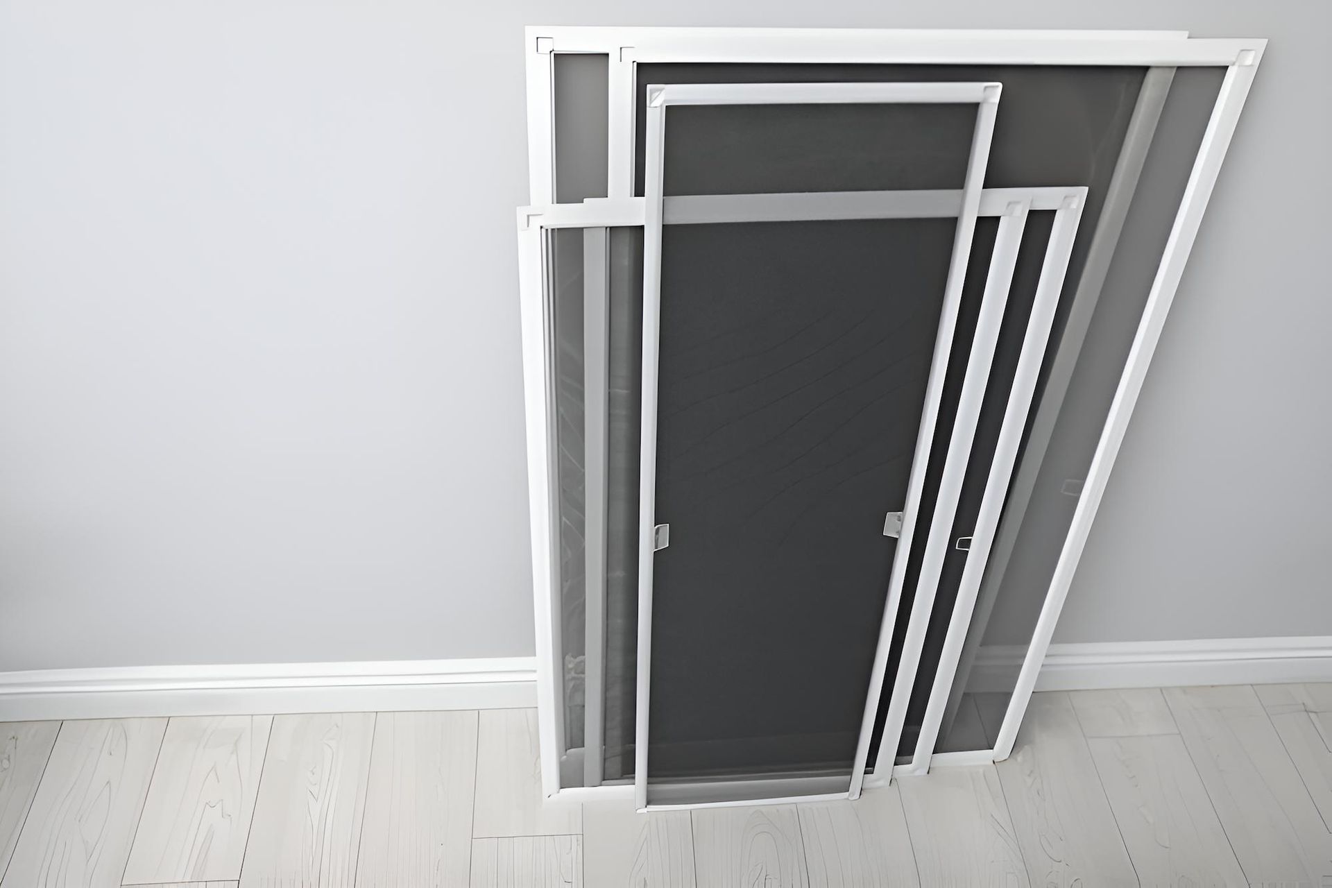 A Bunch of Screen Doors Are Stacked on Top of Each Other in a Room — Manning Blinds & Awnings in Forster, NSW