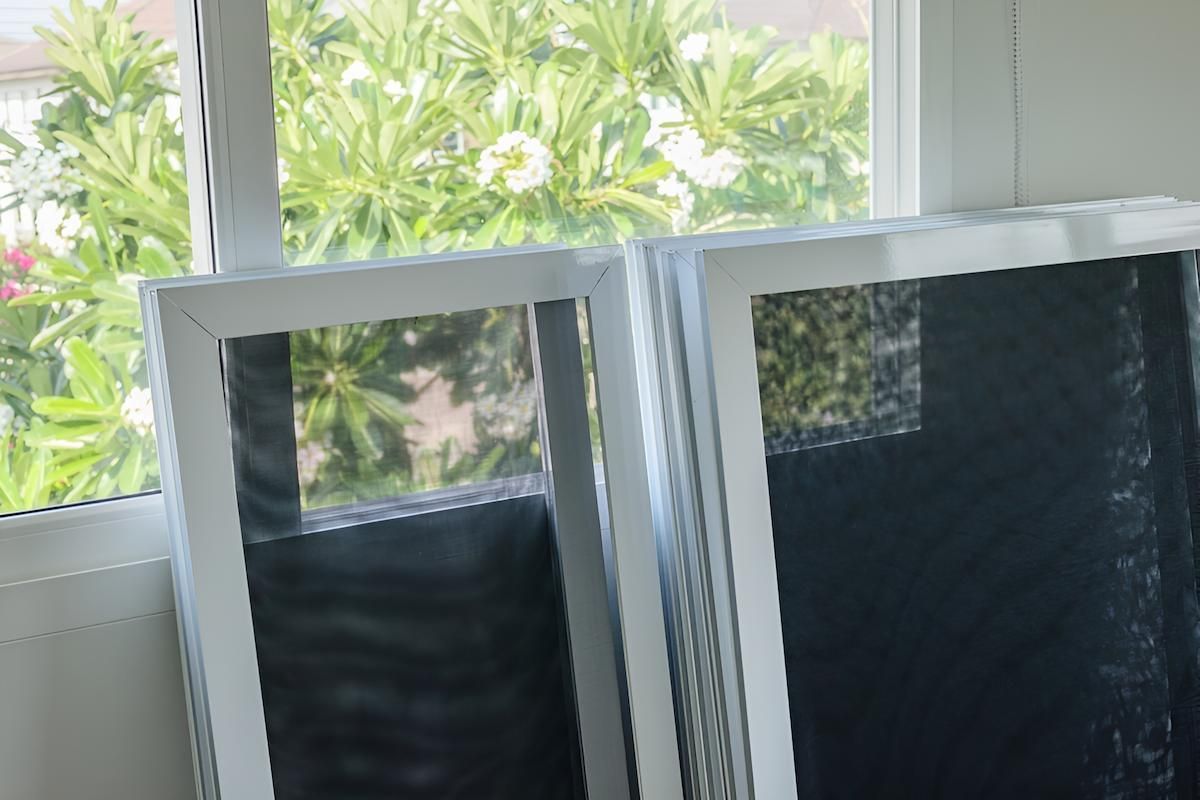 Two Frames Are Sitting on a Table in Front of a Window — Manning Blinds & Awnings in Old Bar, NSW