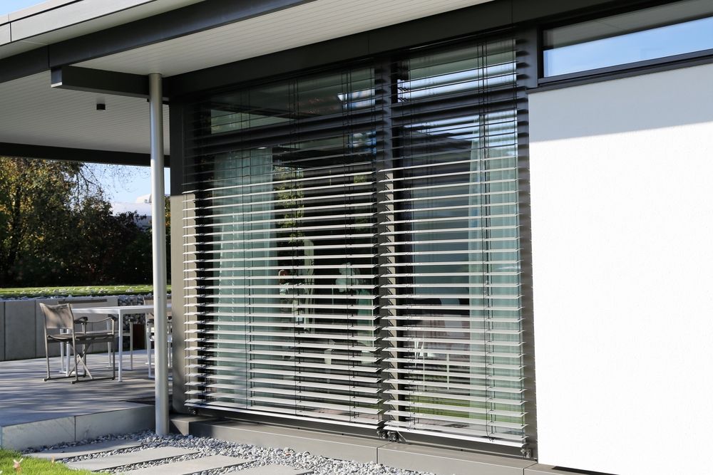 A House With a Sliding Glass Door With Blinds on It — Manning Blinds & Awnings in Hallidays Point, NSW