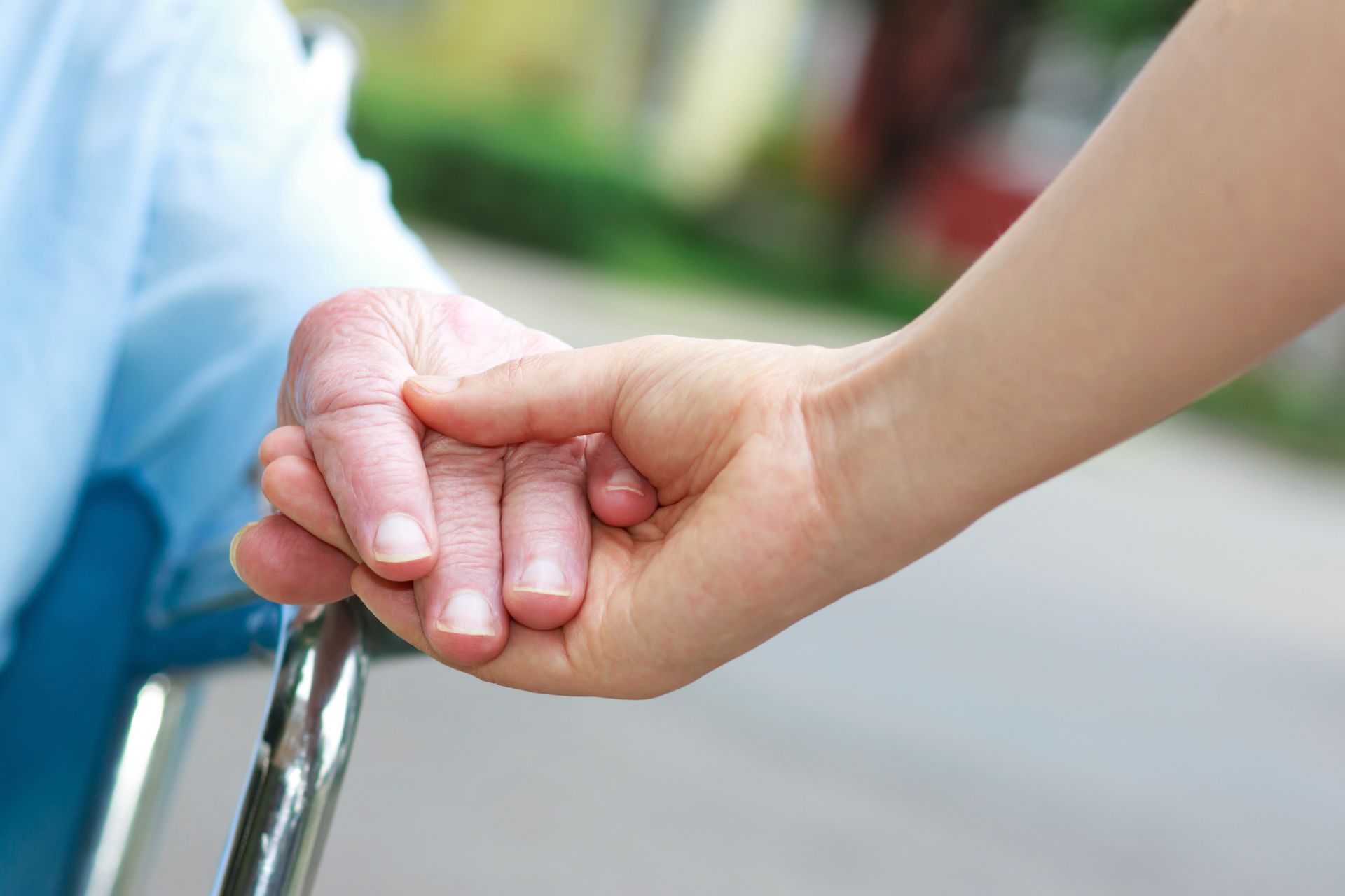 Senior women in wheelchair holding hands receiving Dementia Senior Care Services in Hershey Pa