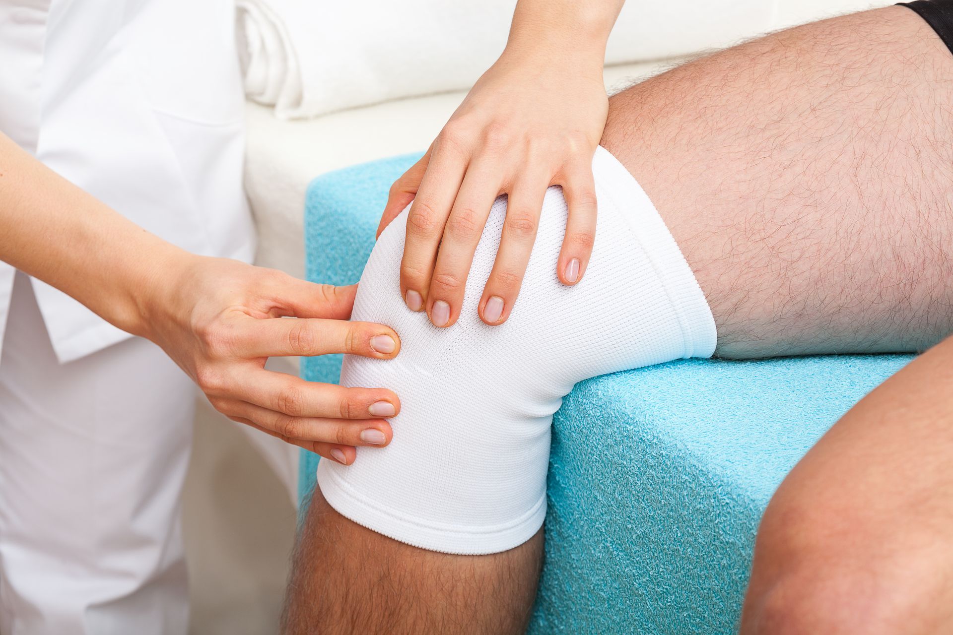 A doctor is providing urgent medical care while examining a patient’s twisted knee.