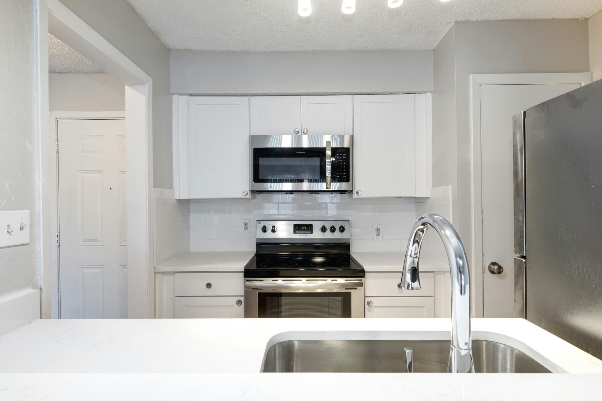 A kitchen with stainless steel appliances and white cabinets