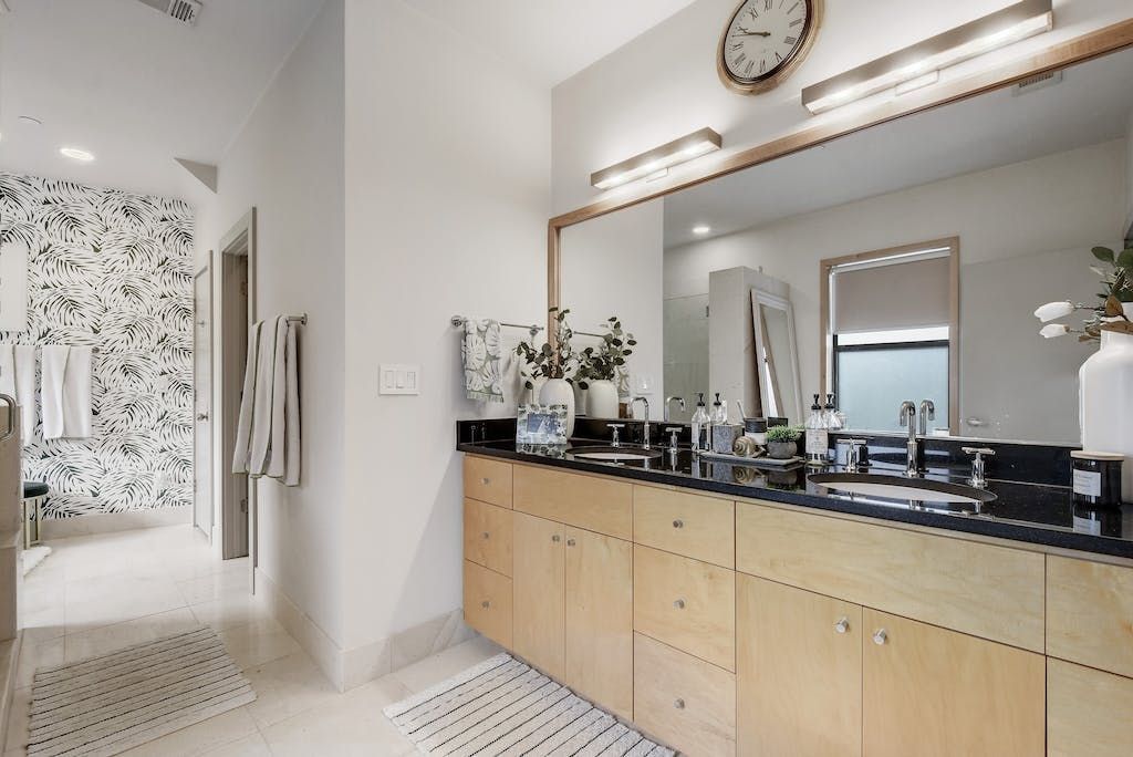 A bathroom with two sinks and a large mirror.
