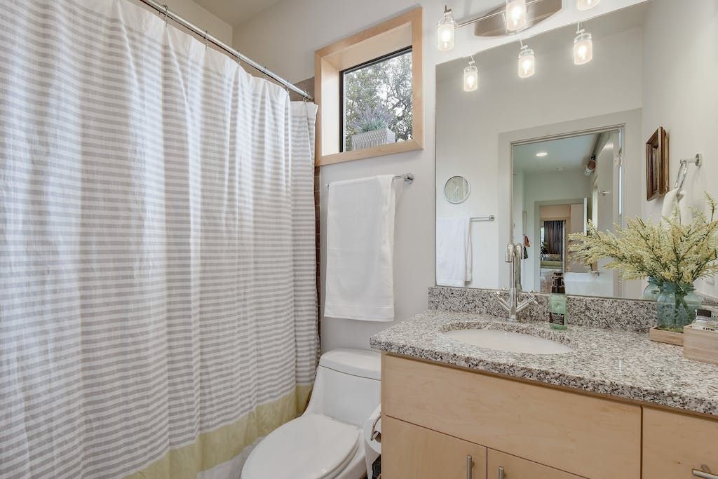A bathroom with a toilet , sink and shower curtain.