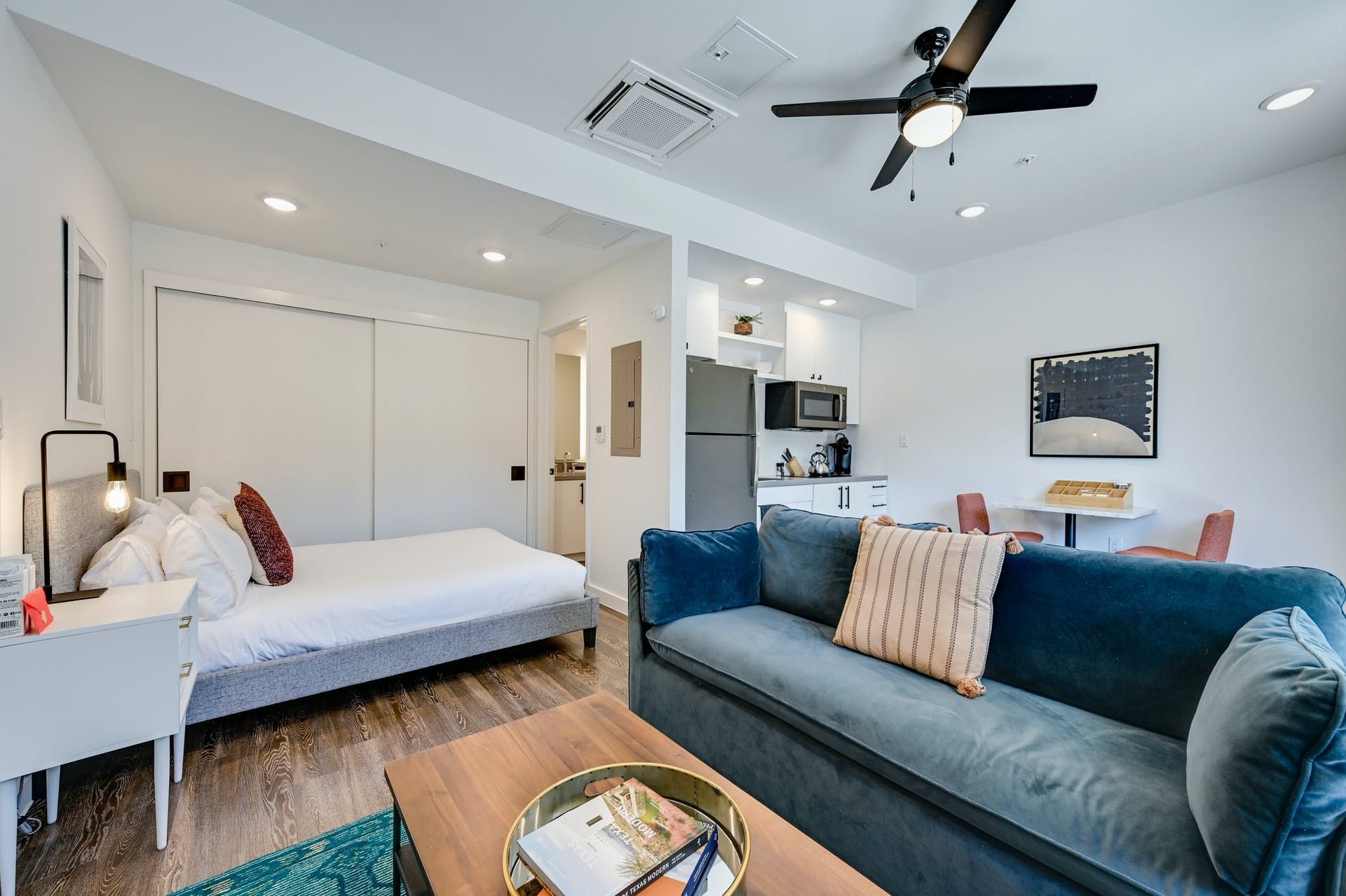 A living room with a couch and a bed and a ceiling fan.