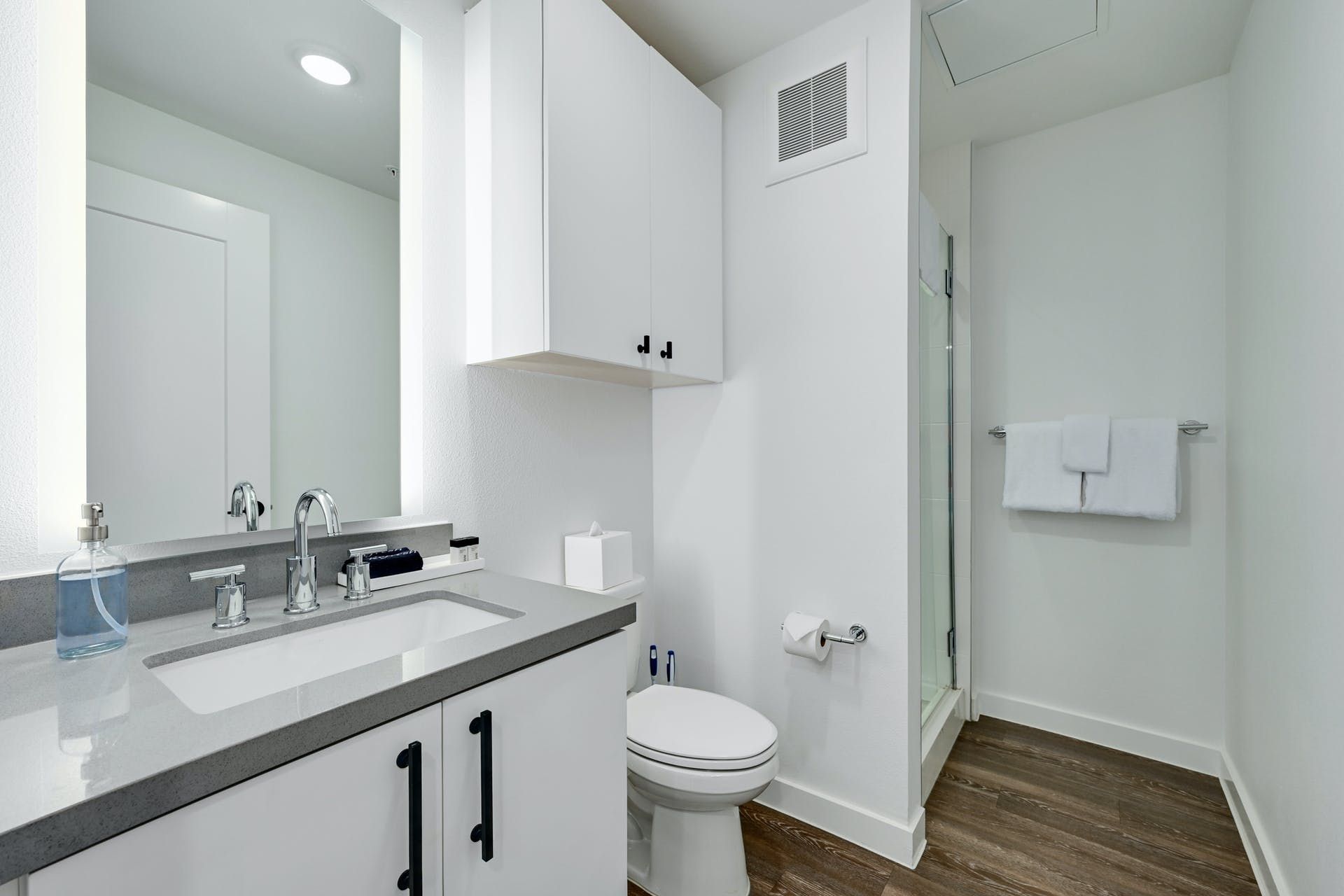 A bathroom with a sink , toilet and mirror.