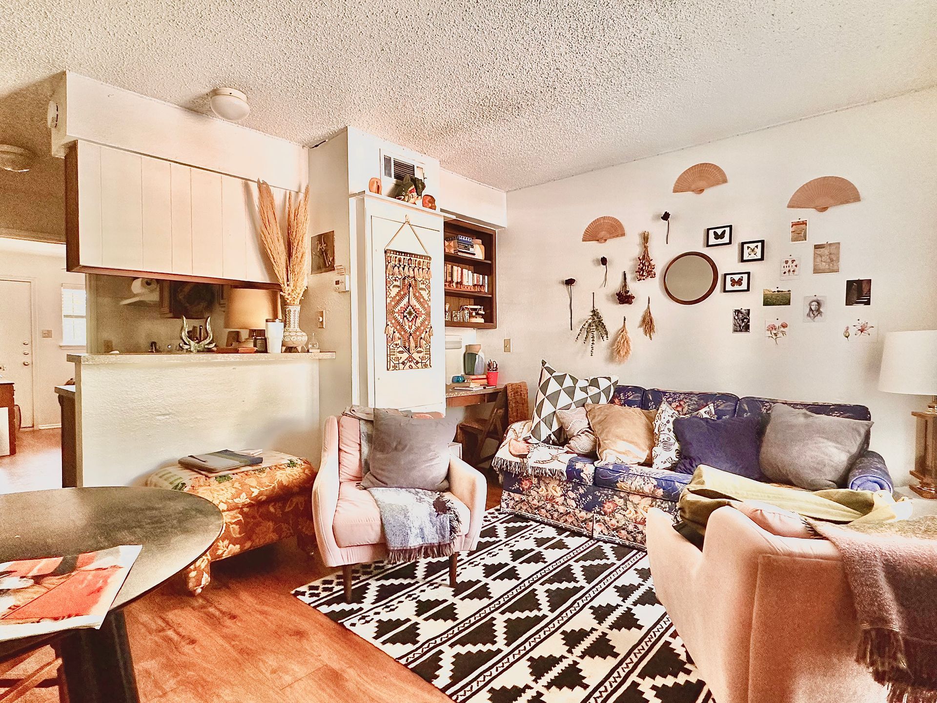 A living room with a couch and chairs and a rug