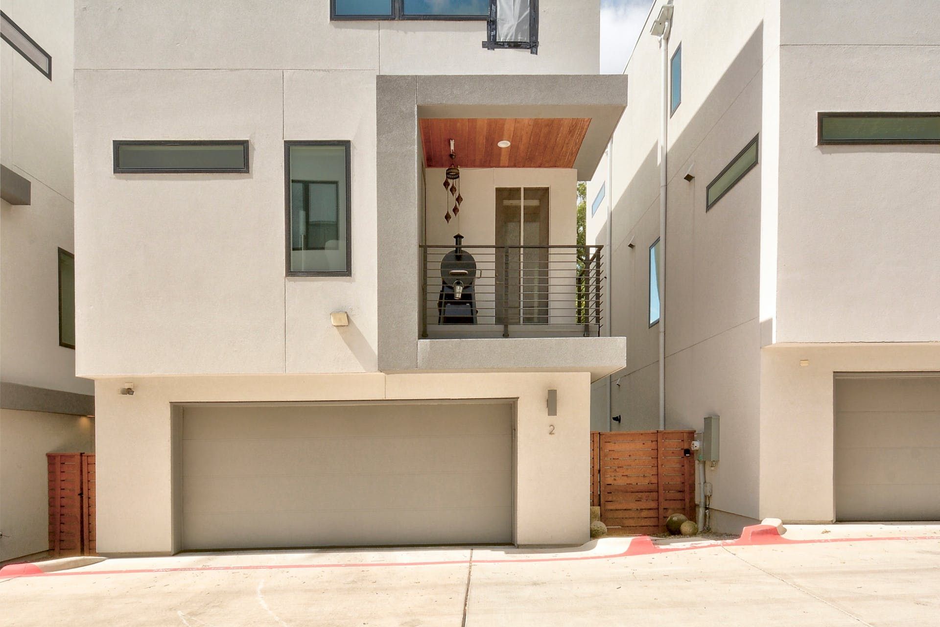 A white house with a garage and a balcony
