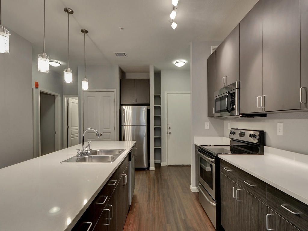 A kitchen with stainless steel appliances and gray cabinets
