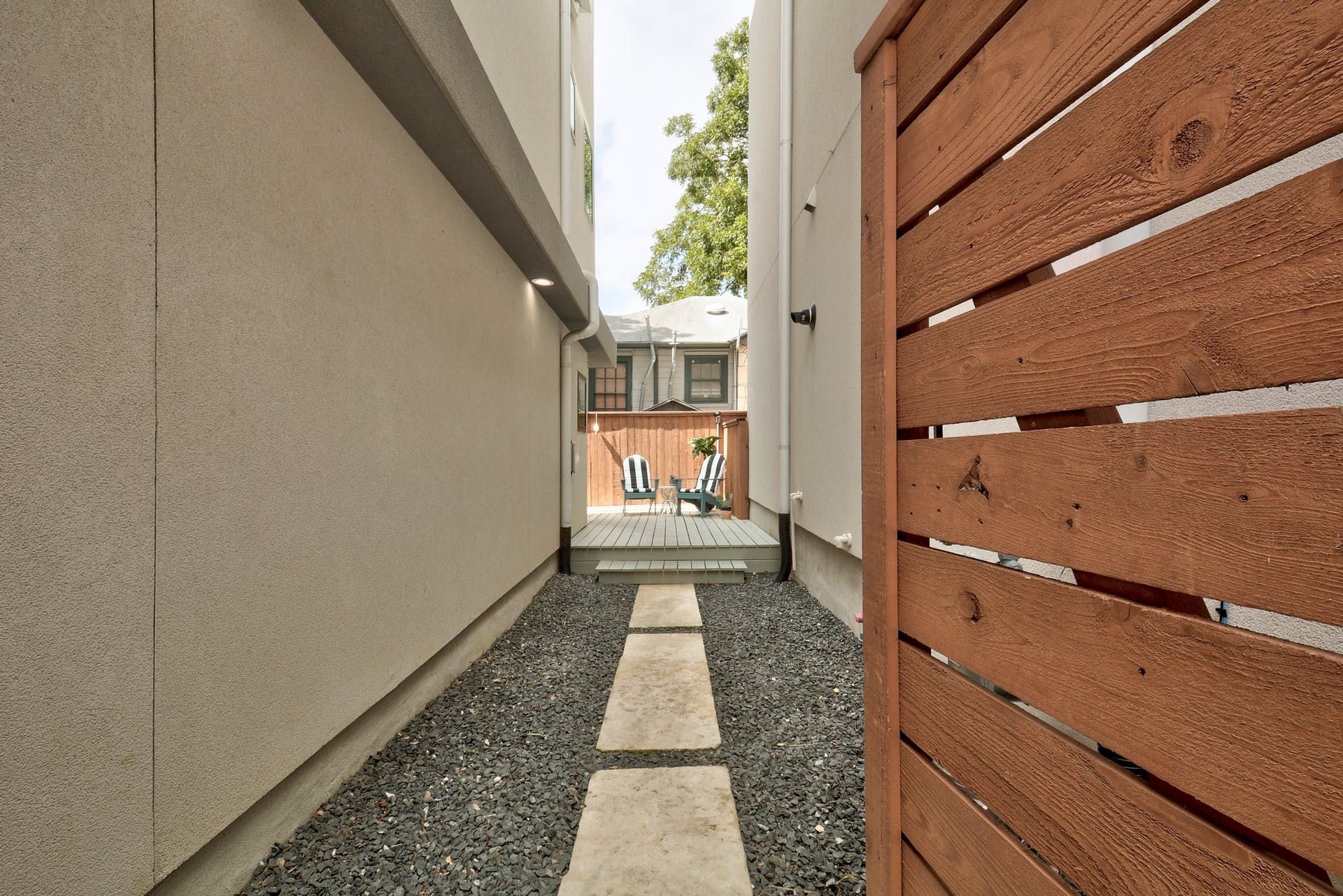A walkway between two buildings with a wooden fence