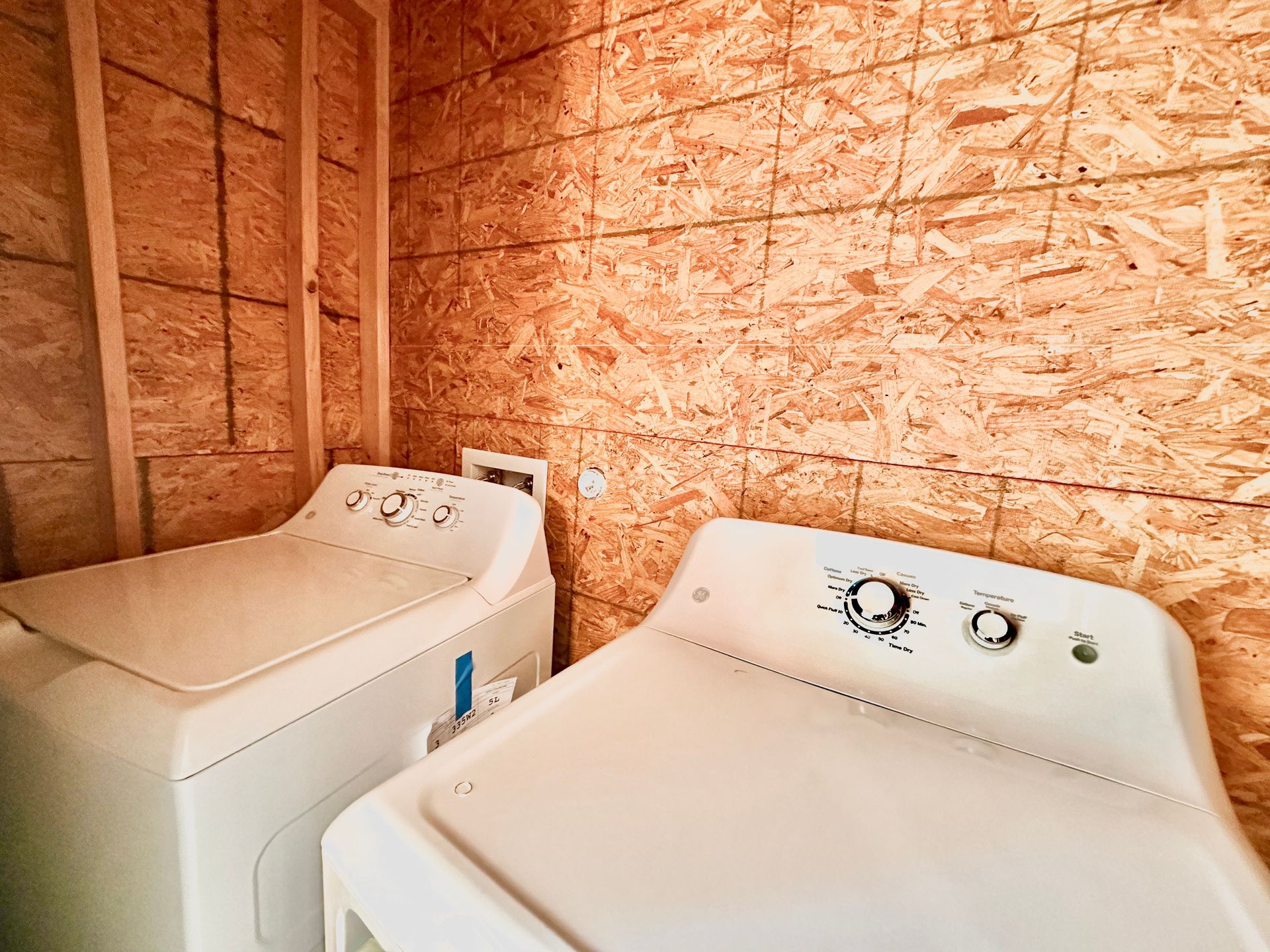 A washer and dryer are sitting next to each other in a laundry room.