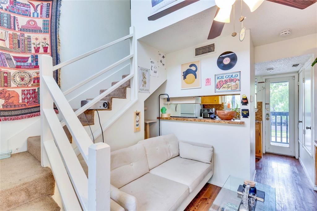 A living room with a couch and stairs leading up to the second floor.