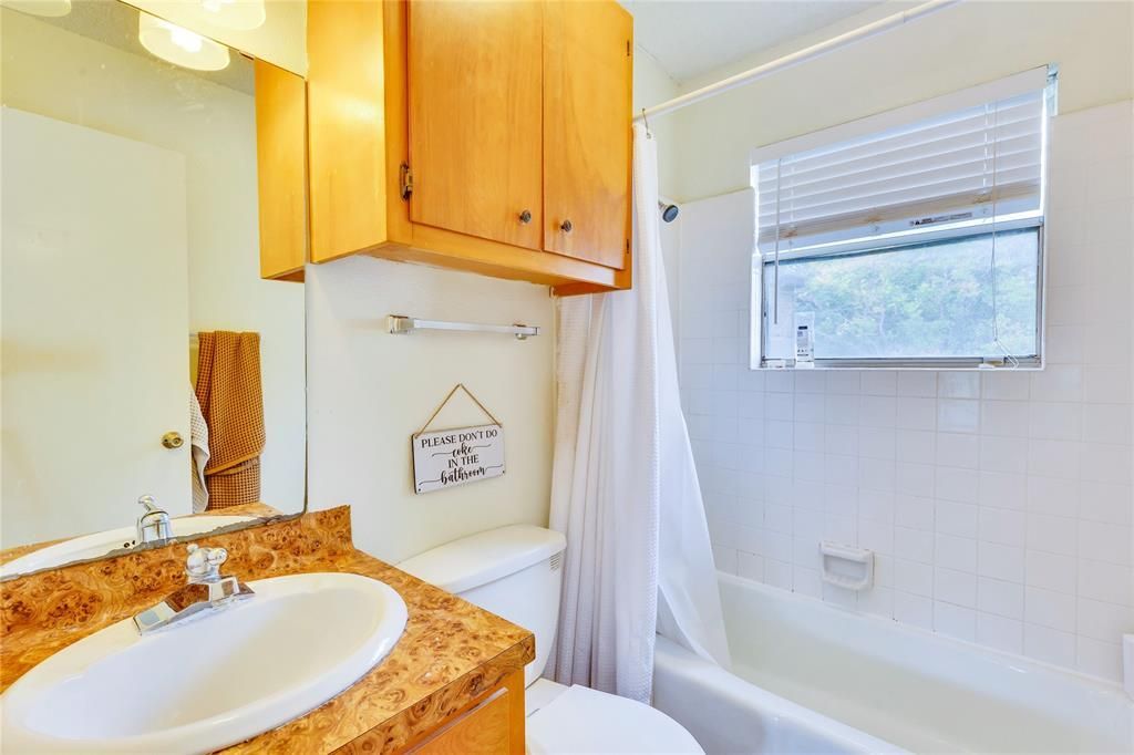 A bathroom with a sink , toilet , tub and mirror.