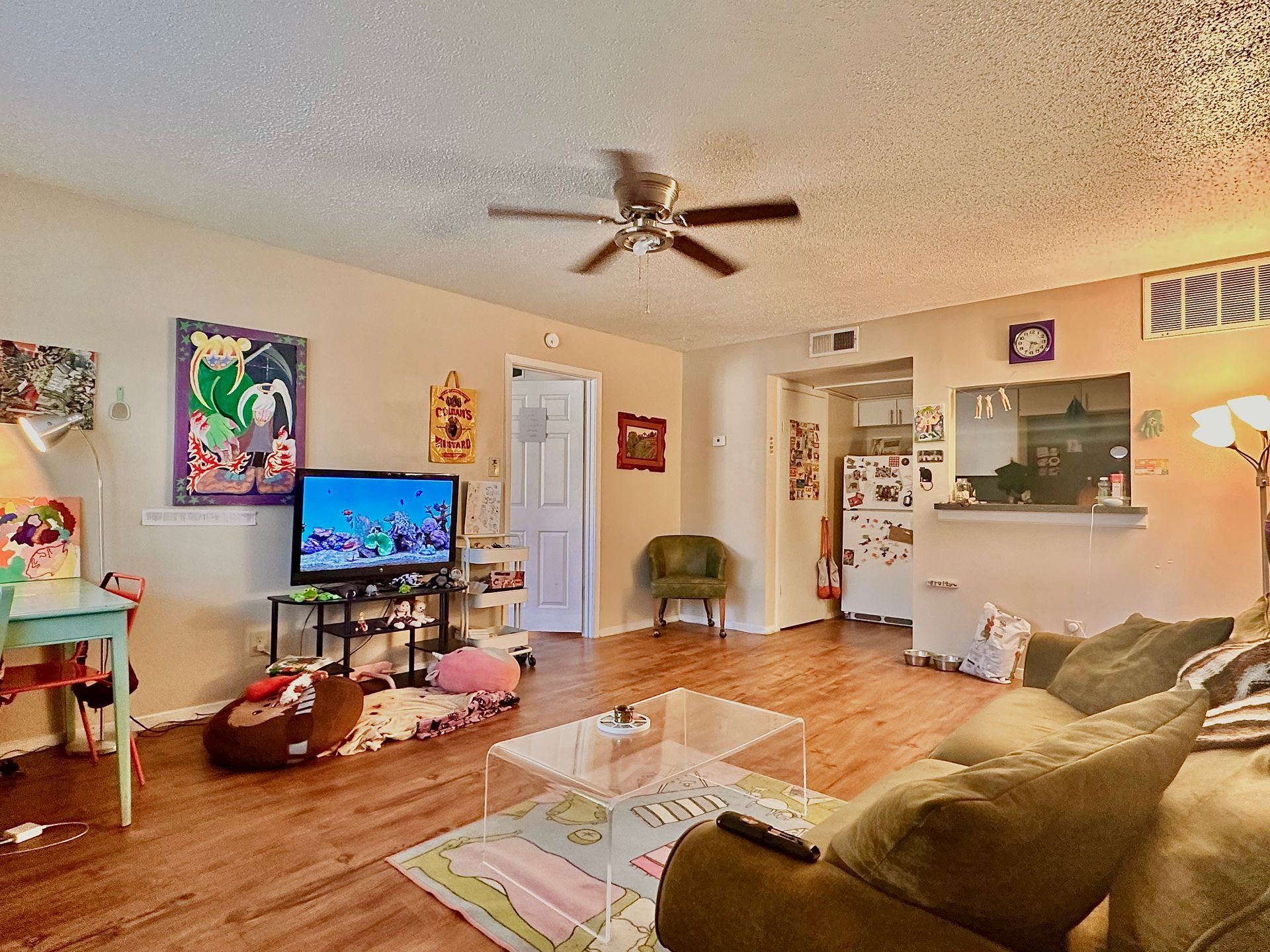 A living room with a ceiling fan and a flat screen tv