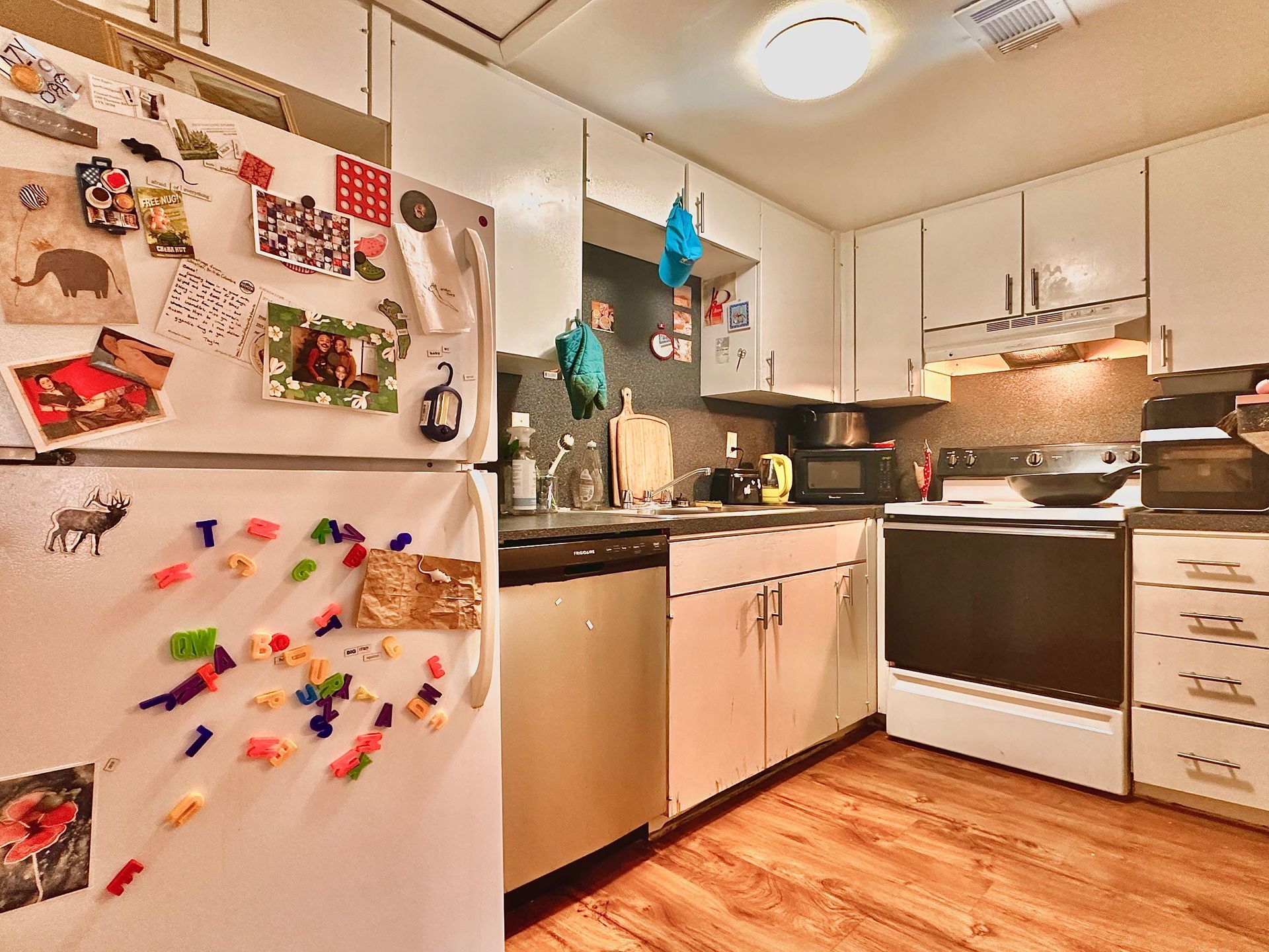 A kitchen with a refrigerator that has a lot of magnets on it.