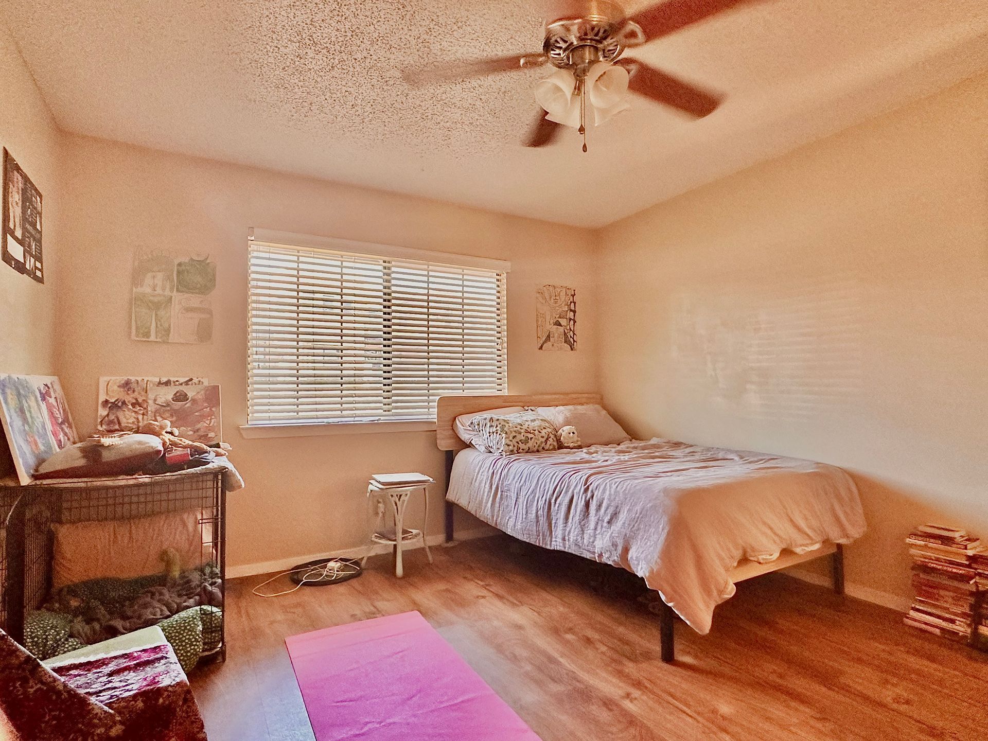 A bedroom with a bed and a ceiling fan