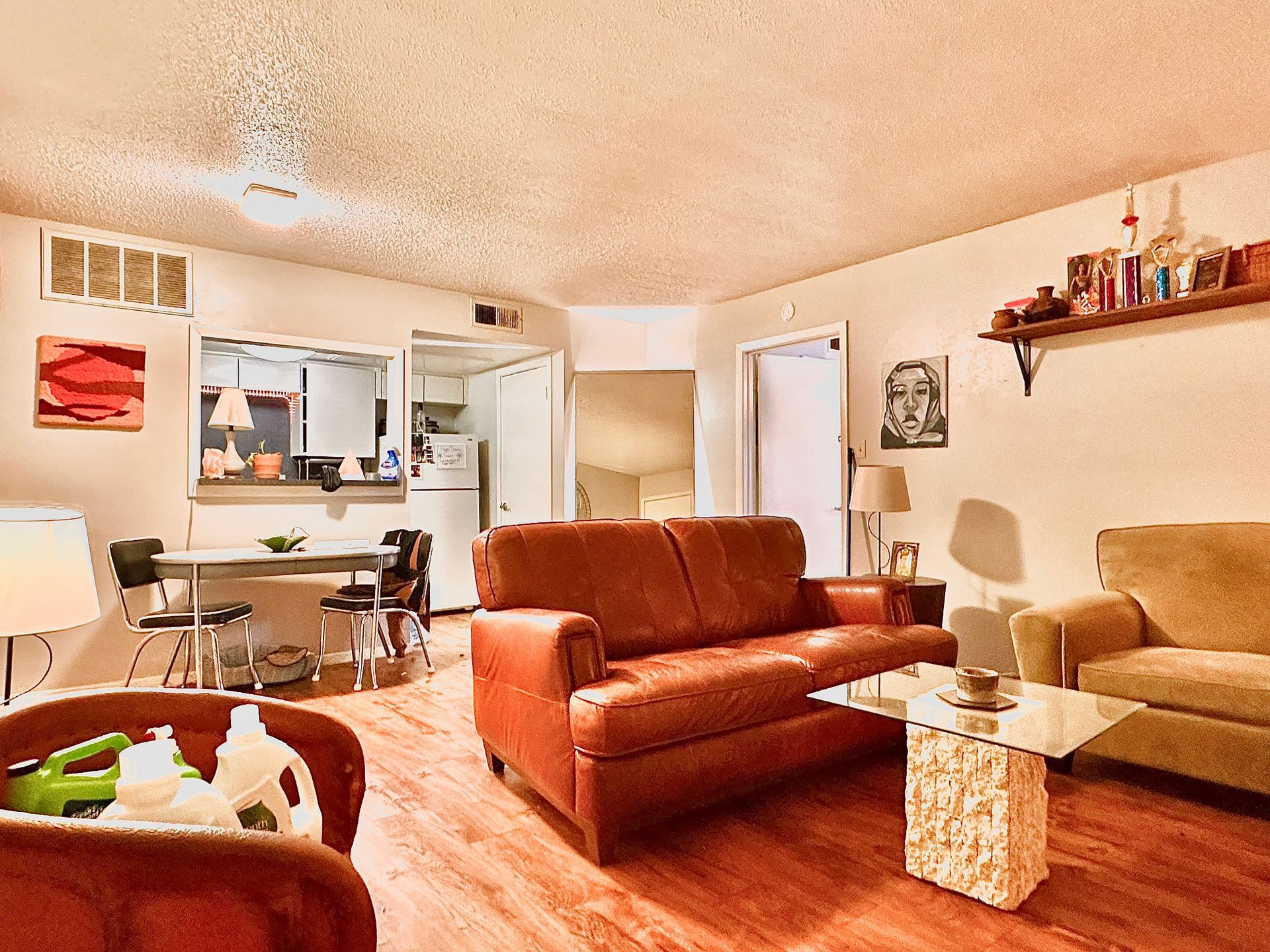 A living room with a brown couch and a glass coffee table