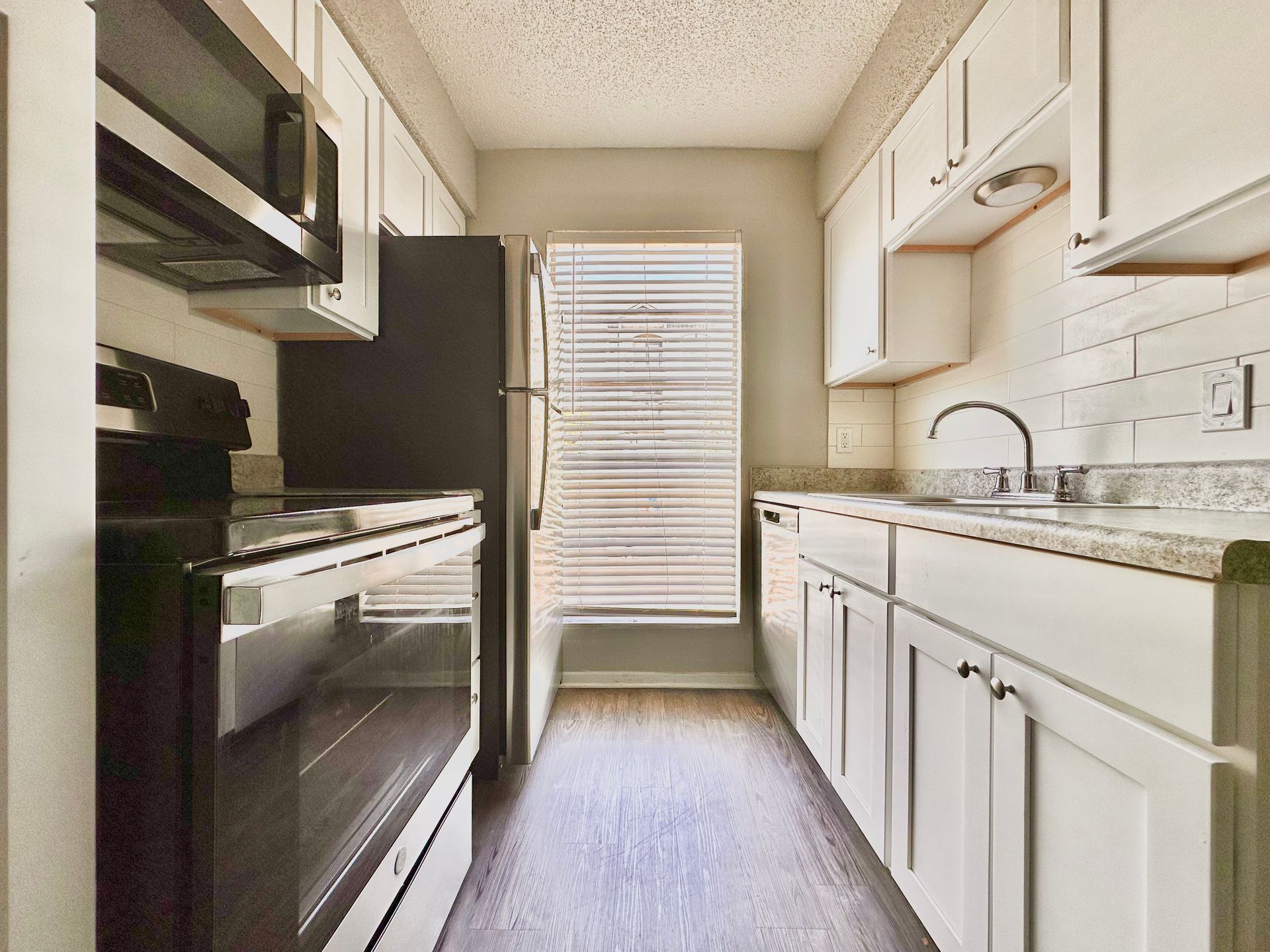 A kitchen with white cabinets and stainless steel appliances