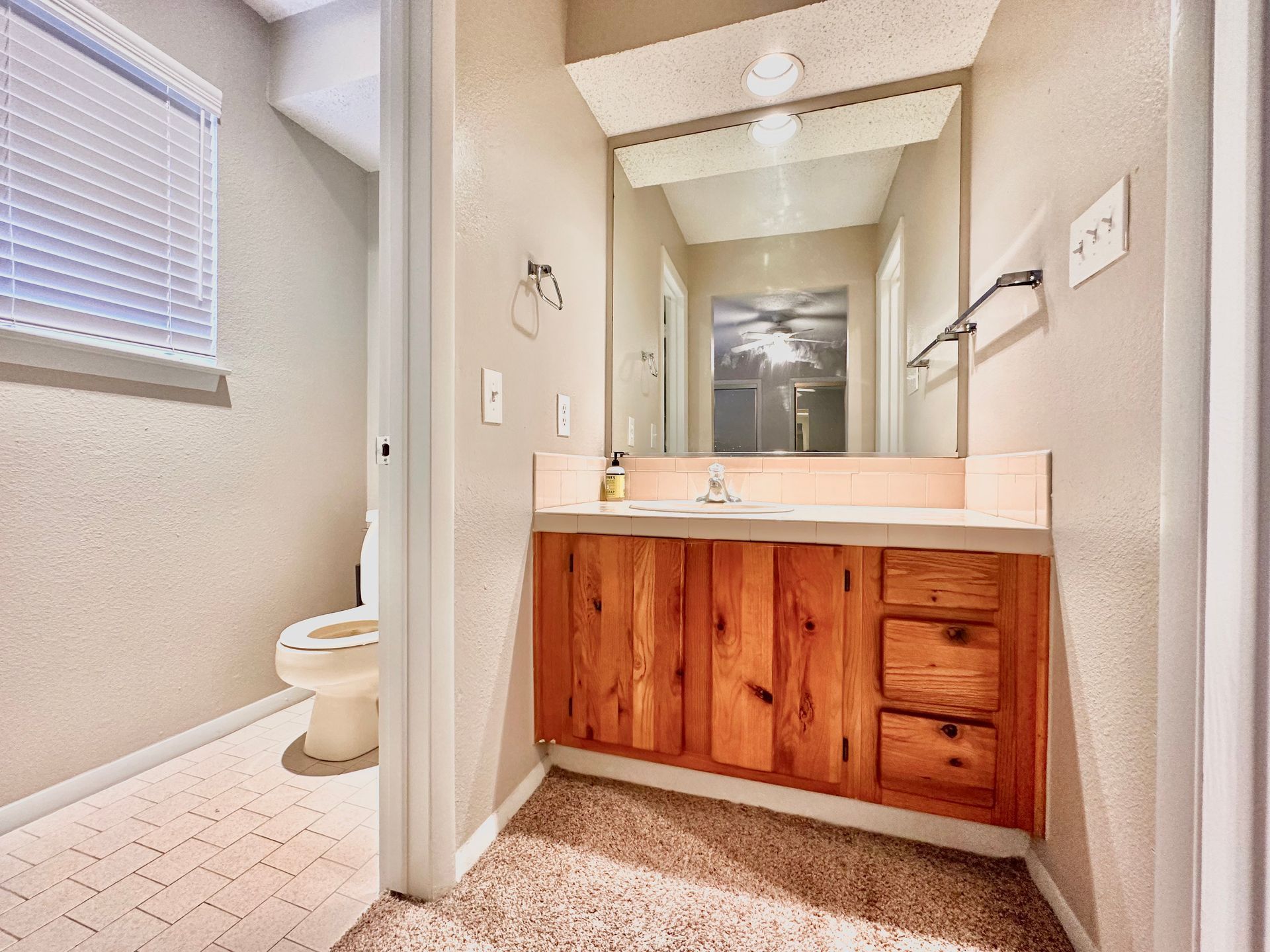 A bathroom with a sink , toilet and mirror.