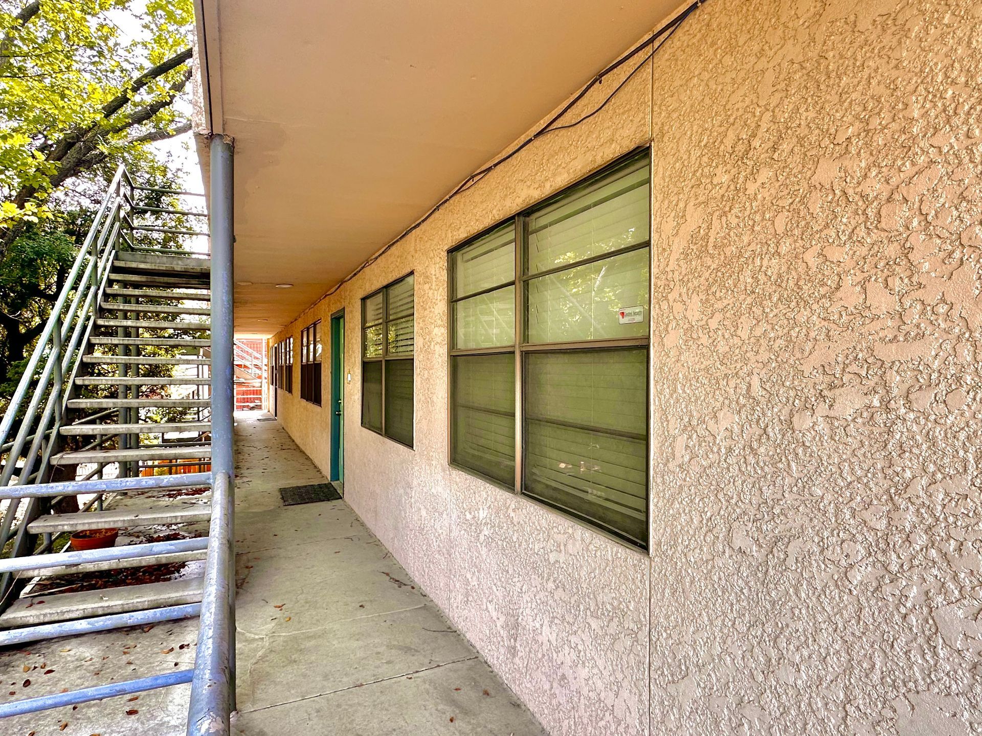 A long hallway between two buildings with stairs and windows.