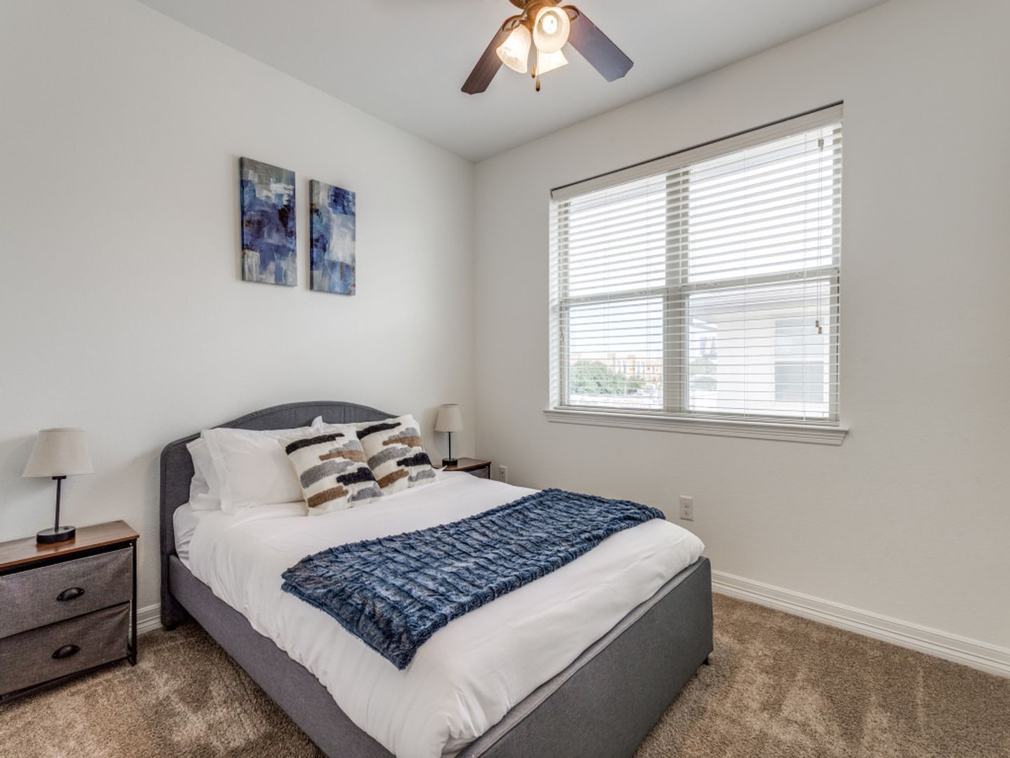 A bedroom with a bed and a ceiling fan