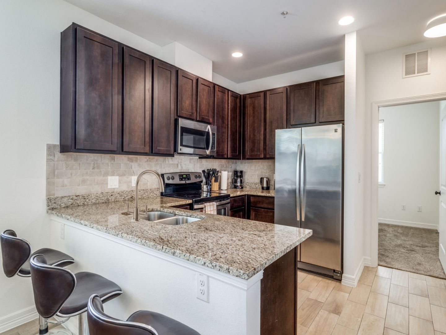 A kitchen with stainless steel appliances and granite counter tops.