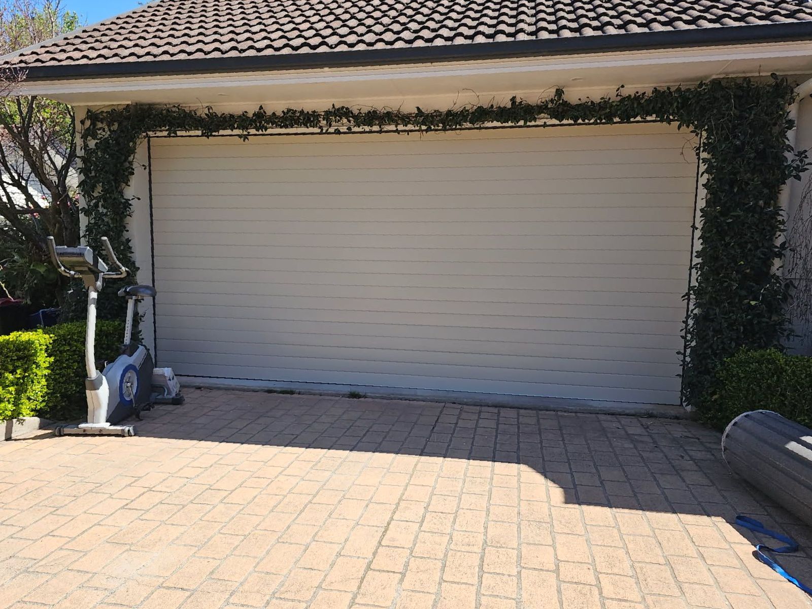 A Tractor is Parked in a Garage With the Door Open — Schofield's Garage Doors in Robertson, NSW