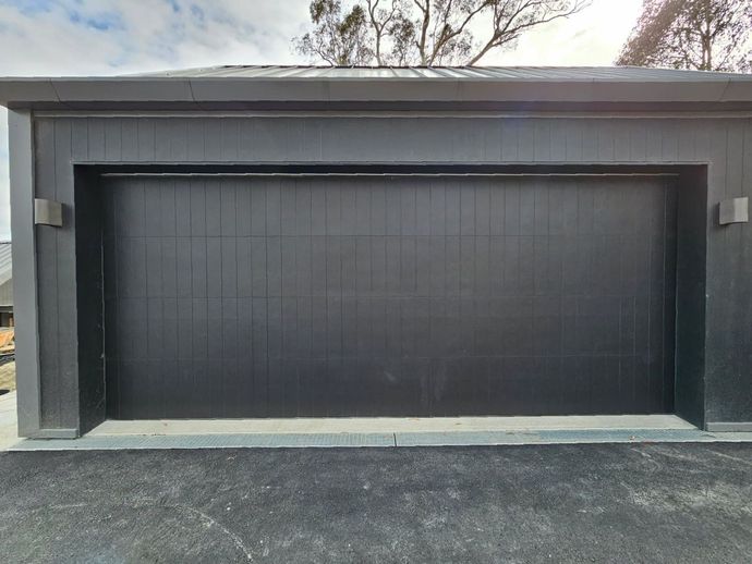 A House With a Large Garage and a Lush Green Lawn — Schofield's Garage Doors in Robertson, NSW