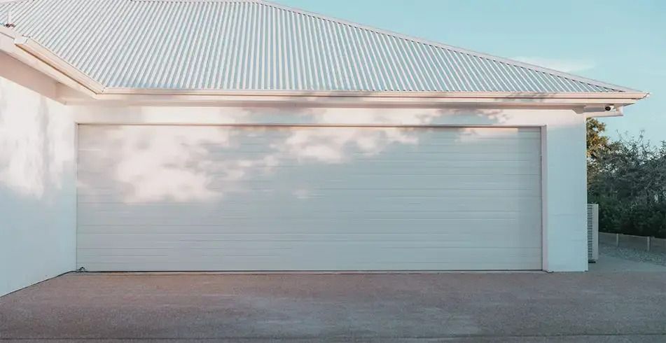 A White Garage With a White Roof and a White Garage Door — Schofield's Garage Doors in Robertson, NSW