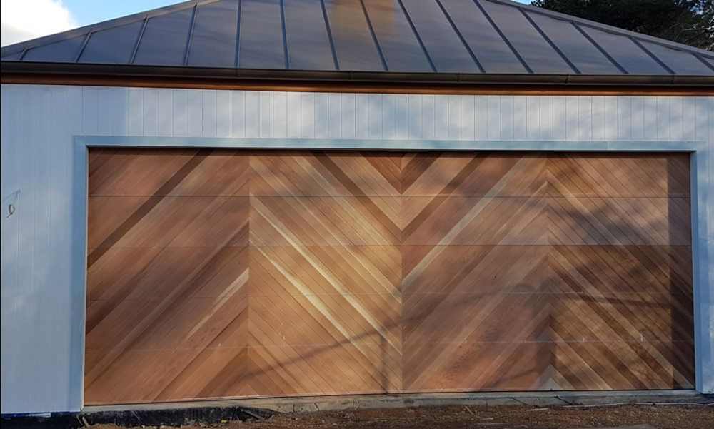 A Man is Measuring a Garage Door With a Tape Measure — Schofield's Garage Doors in Robertson, NSW
