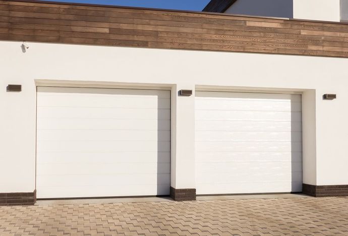 There Are Two White Garage Doors on the Side of a House — Schofield's Garage Doors in Robertson, NSW