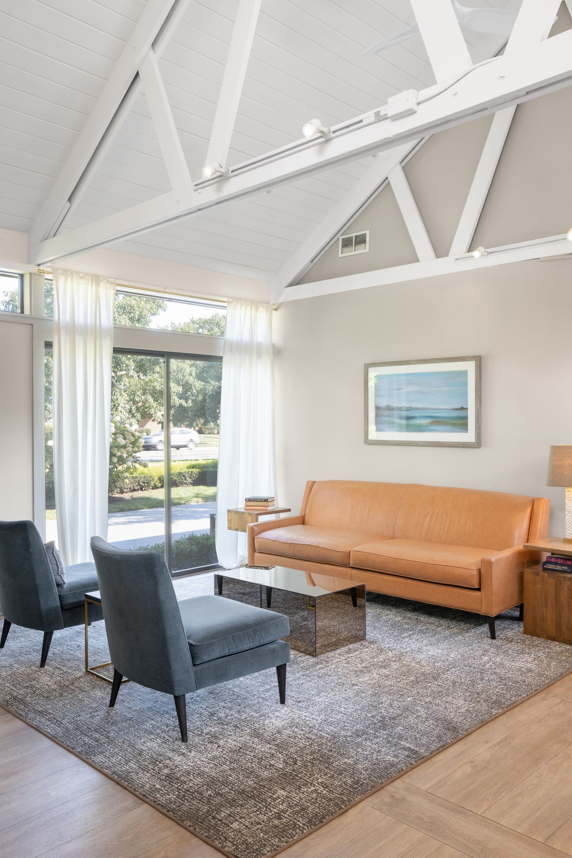 A living room with a couch , chairs , and a rug.
