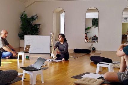 A bottle of water is sitting on a box in a yoga studio.