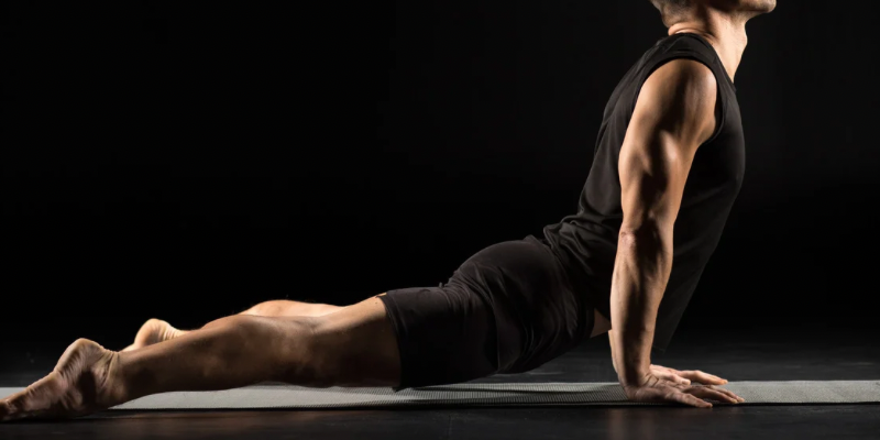 A man is doing a yoga pose on a yoga mat.