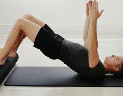 Two women are doing sit ups on the floor.