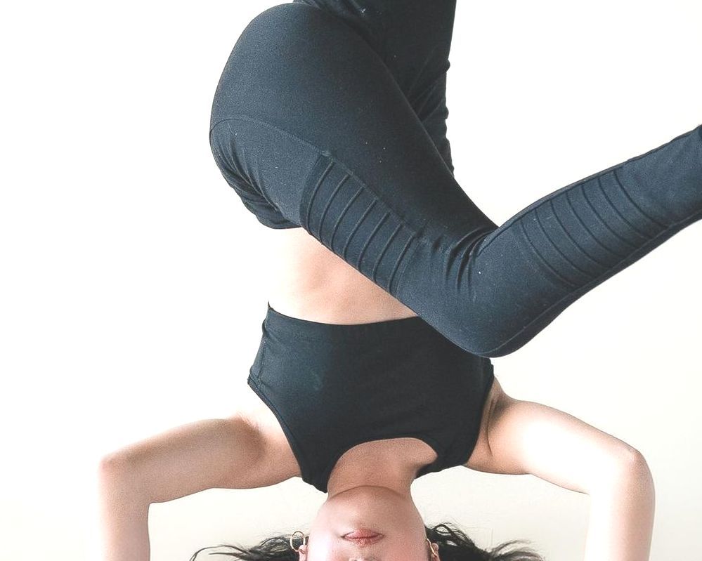 A woman is doing a headstand on her head