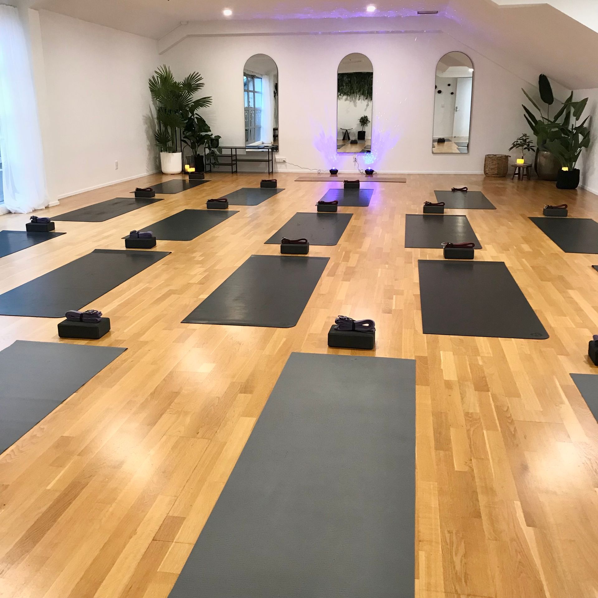 A woman is doing a handstand on a yoga mat in a room.