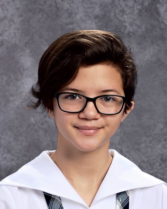 A young girl wearing glasses and a white shirt