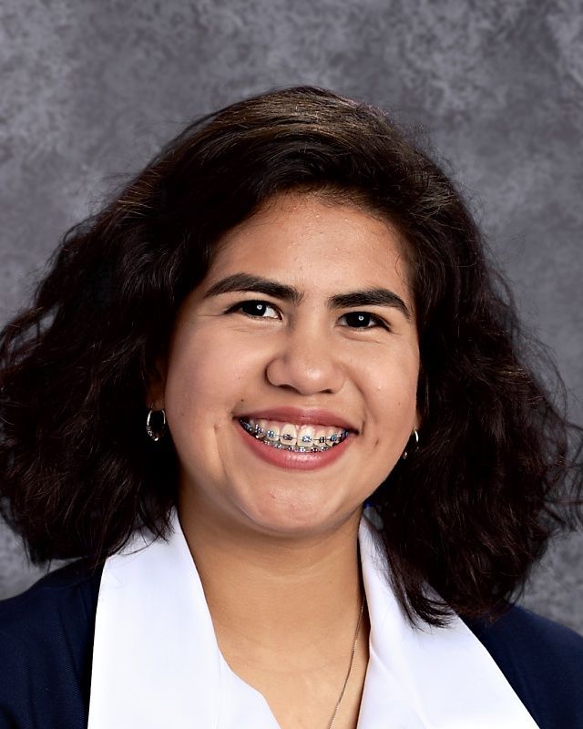 A woman with braces on her teeth smiles for the camera