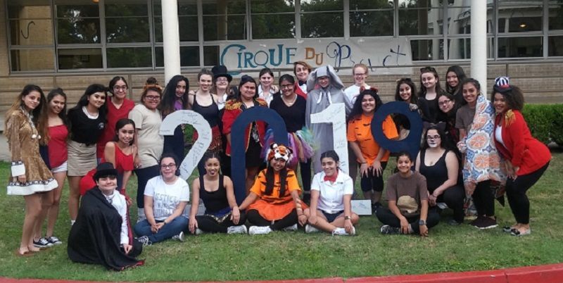 A group of people posing for a picture in front of a sign that says cirque du soleil