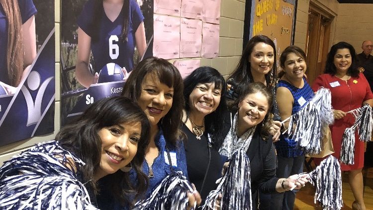 A group of cheerleaders are posing for a picture while holding pom poms.