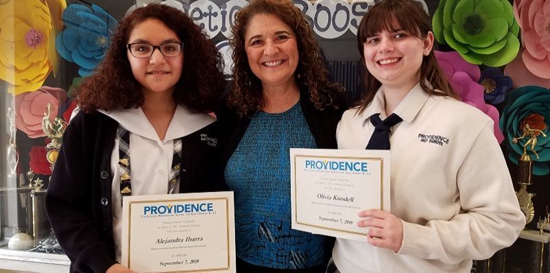 Three girls are standing next to each other holding certificates.