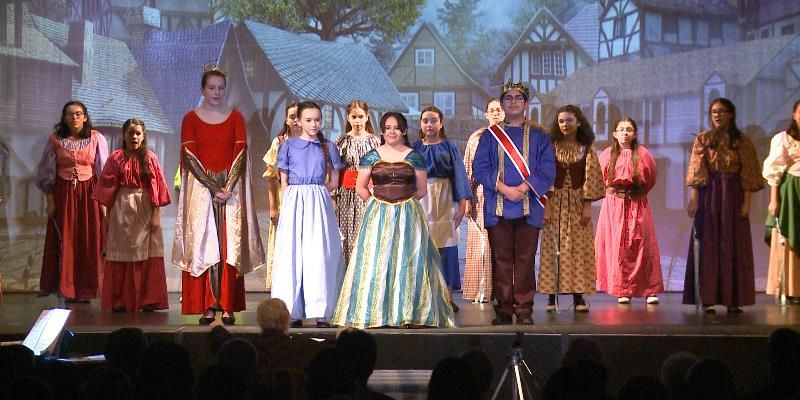 A group of people in costumes are standing on a stage