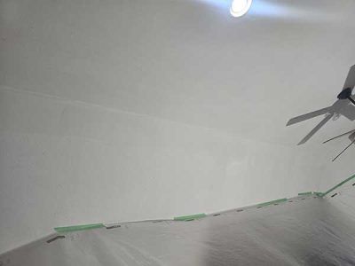 Ceiling fan, and ceiling; a room is being painted white with painter's tape visible.