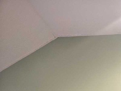 Corner of a room with a white ceiling and light green wall.