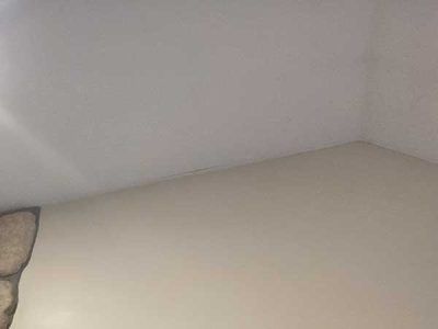 Interior corner of a room with a white ceiling and beige walls.