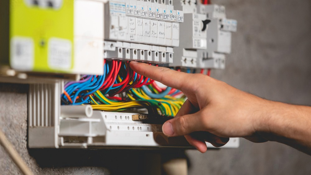 a person is plugging wires into an electrical box .