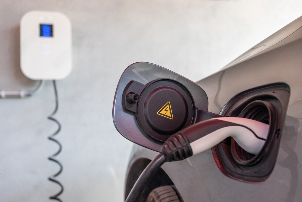 an electric car is being charged at a charging station .